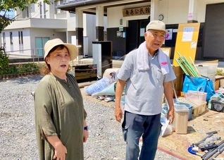 災害ごみ置き場に立つ村田さん㊨は「なーん、私なんかすごくなかですよ。当たり前のことばしよっとだけん」。情熱の“肥後もっこす”に妻・千穂子さんは明るく伴走する