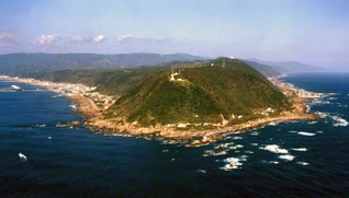 今も隆起し続ける室戸半島。手前の白亜の灯台「室戸岬灯台」が立つ高台は、10～12万年前は海の中だった（室戸ジオパーク推進協議会提供）