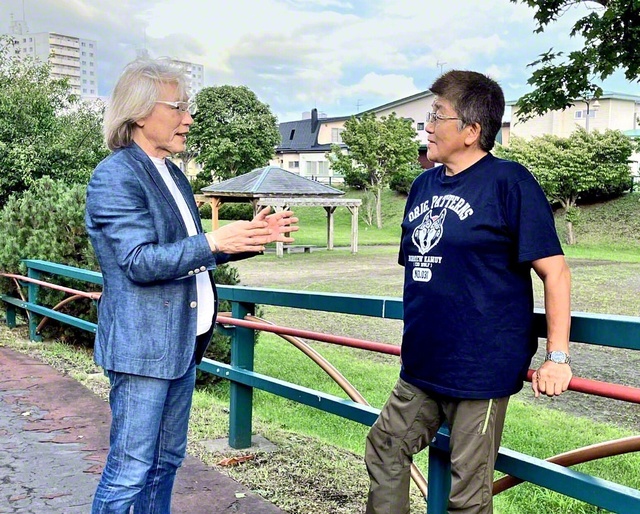 折伏した友と地域広布について語り合う横内さん㊧。目の前の一人を徹底して大切にし、温かな励ましを送る