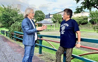 折伏した友と地域広布について語り合う横内さん㊧。目の前の一人を徹底して大切にし、温かな励ましを送る