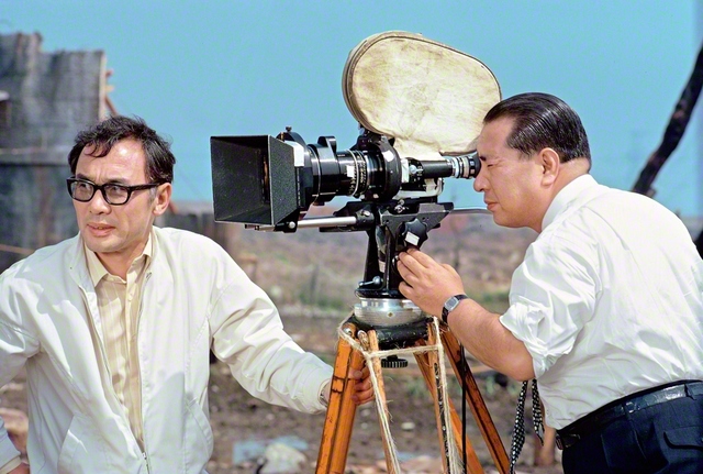 1973年4月25日、映画「人間革命」のロケ現場を視察した池田先生（東京・江戸川区で。左は舛田利雄監督）。映画製作に寄せて、こうつづった。「幾人もの人々が、同じ志を頒（わか）ち合う共同作業は、必ずその苦闘の果てに、総合芸術としての比類のない輝きをもたらす」