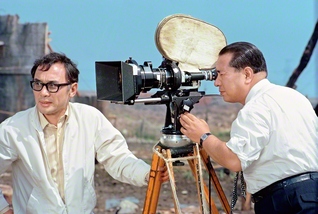 1973年4月25日、映画「人間革命」のロケ現場を視察した池田先生（東京・江戸川区で。左は舛田利雄監督）。映画製作に寄せて、こうつづった。「幾人もの人々が、同じ志を頒（わか）ち合う共同作業は、必ずその苦闘の果てに、総合芸術としての比類のない輝きをもたらす」