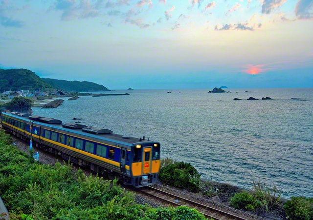 夕暮れ時の日本海沿いを、特急「スーパーおき」が駆け抜ける＝島根・岡本克正通信員