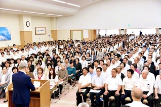 原田会長が出席した山梨総県の幹部会。金澤主任副会長があいさつし、光の城合唱団が歌声を披露した（山梨文化会館で）
