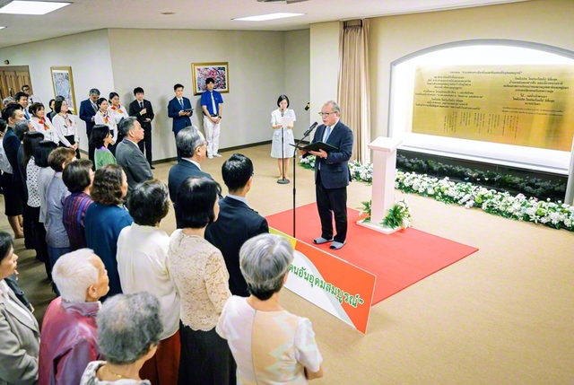 タイ本部の大広間「歓喜講堂」前のロビーで行われた銘板の除幕式。銘板には、長編詩「微笑の国　豊饒の大地」の結びの一節がタイ語と日本語で刻まれている（15日、バンコク近郊で）