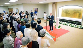 タイ本部の大広間「歓喜講堂」前のロビーで行われた銘板の除幕式。銘板には、長編詩「微笑の国　豊饒の大地」の結びの一節がタイ語と日本語で刻まれている（15日、バンコク近郊で）