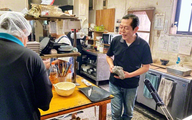 調理場に立つ岩崎さん㊨。特性の違う一人一人を根気強く支えるには「根本は題目しかなか。相手を思う真心はちゃんと通じます」と