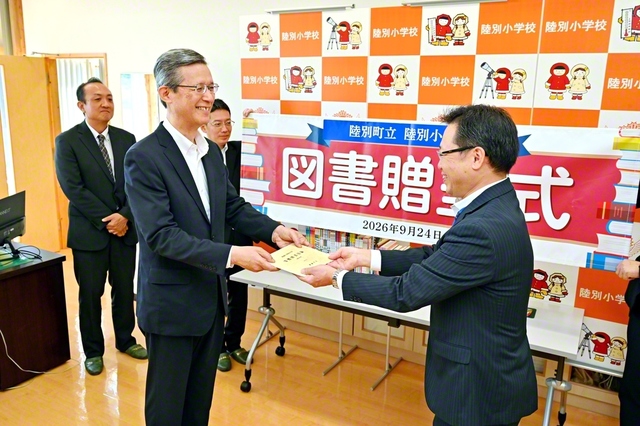 羽磨北海道長㊧から佐藤貴光校長に目録が手渡された（北海道・陸別町の陸別小学校で）