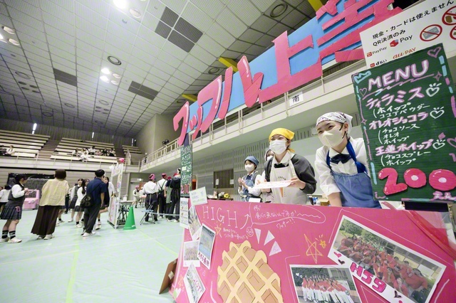 元気いっぱいに来場者に声をかける模擬店の生徒たち
