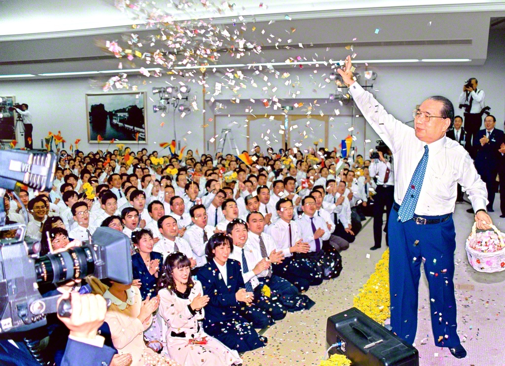 「大分新世紀総会・レインボー音楽祭」で、同志の奮闘をたたえて紙吹雪を舞わせる池田先生（1992年3月1日、大分池田講堂〈現・大分平和講堂〉で）