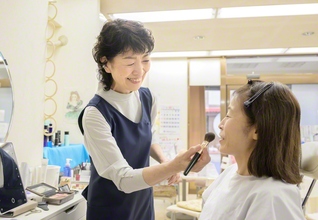 齋藤さん㊧がお客にメークを。結婚式や同窓会など大切な日を前に店を訪れる人も多いという