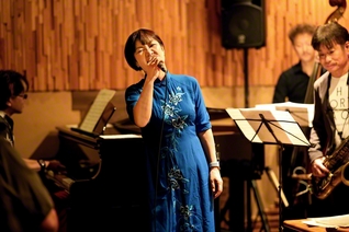ジャズバーで歌声を響かせる田中さん。「つらい経験も自分を成長させてくれた」。題目を唱え、夢をかなえる中で全ての人に感謝できるようになった