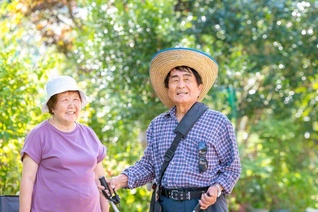 自宅の庭で瀬賀さん㊨が妻・みどりさんと語り合う。瀬賀さんは大腸がんを患っても懸命な題目で乗り越えてきた