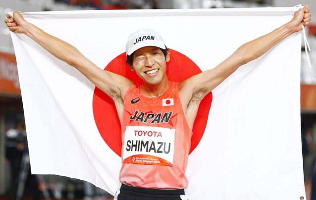 陸上の男子5000メートル（視覚障害T12、13）で優勝し日の丸を広げる嶋津