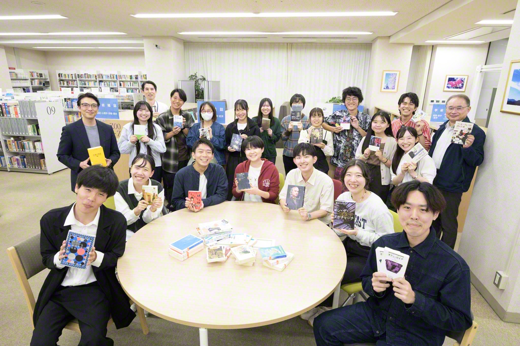 創価大学の「SRP」の学生と職員が“推しの一書”を手に（同大学中央図書館で）