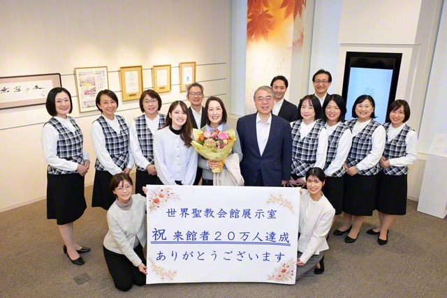 来場者20万人を祝して記念のカメラに納まった（世界聖教会館の展示室で）