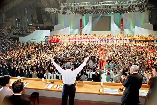 「世界青年平和大文化総会」のフィナーレで、後継の青年たちとカチャーシーを舞う池田先生。後に先生はつづった。「君よ舞え！　私も舞う！　君よ戦え！　私も戦う！」（「随筆　人間世紀の光」）（2000年2月5日、沖縄コンベンションセンターで）