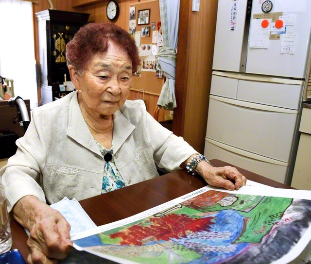 池原さんが描いた「沖縄戦の絵」を見つめる