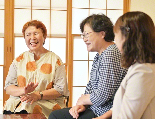 知人と語らう菅野さん㊧。聖教拡大をはじめ、多くの友への仏法対話にも挑戦している