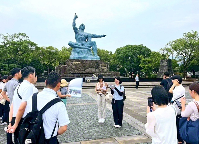 長崎市の平和公園で不戦を誓う田中さん（中央右）