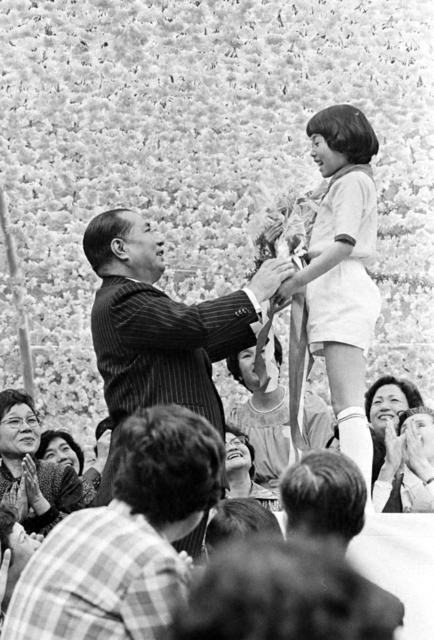 「三重文化合唱祭」の席上、少女部員から花束を受け取り、宝の未来部に万感の期待を寄せる池田先生（1978年4月23日、三重研修道場で）