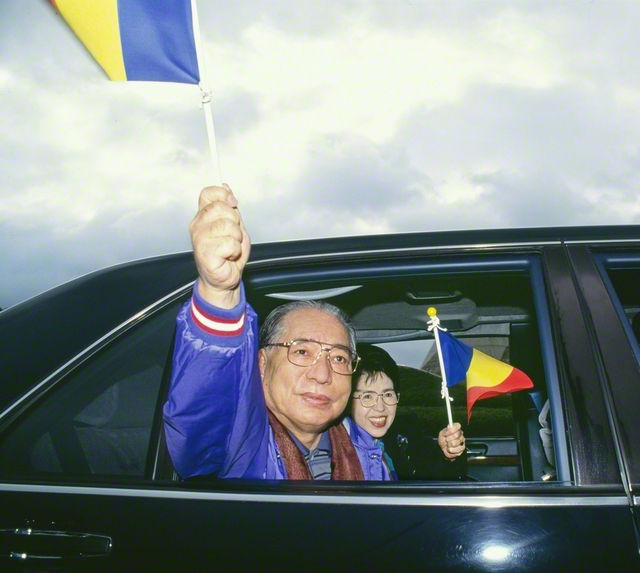 寒風の中、同志のために三色旗を振り続ける池田先生と奥さま（1992年12月17日、中部池田記念墓地公園で）