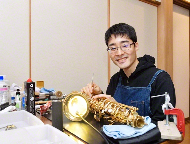 楽器のリペアに精を出す猪狩さん。仕事も信心も一人前を目指して奮闘中