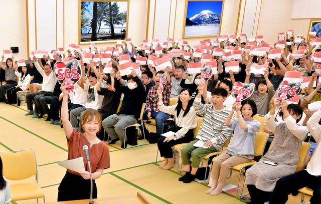 【滋賀】シンガポールの国旗を掲げてエールを送る滋賀文化会館の参加者（12日）