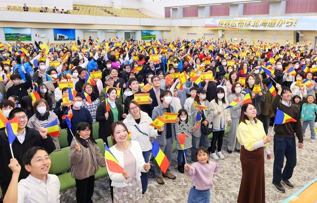 参加者がスペイン国旗と学会の三色旗を手に（26日、北海道池田講堂で）
