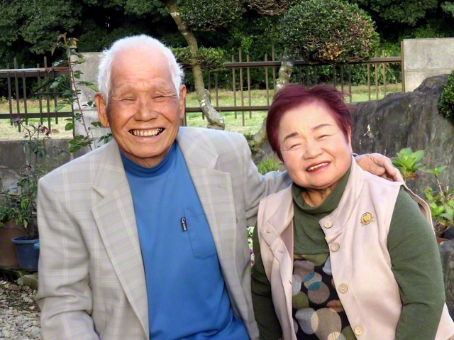 仲むつまじい礒七郎さん㊧と順子さん夫妻が笑みをたたえる