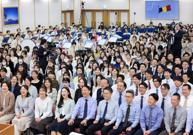 大講堂開館の2027年へ、躍動の心で意気高く開催された関西総会では、都島総区・北斗地区の山口有登地区部長、西井由佳同女性部長が活動報告した（11月30日、関西池田記念会館で）