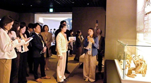 長崎原爆資料館を見学。通訳の説明にじっくりと耳を傾け、熱心にメモを取る一行