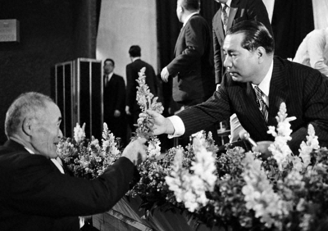 勝浦市市民会館（当時）で開かれた千葉県大会。広布功労の“庶民の王者”をたたえようと、ストックの花を手渡す池田先生（1974年2月16日）