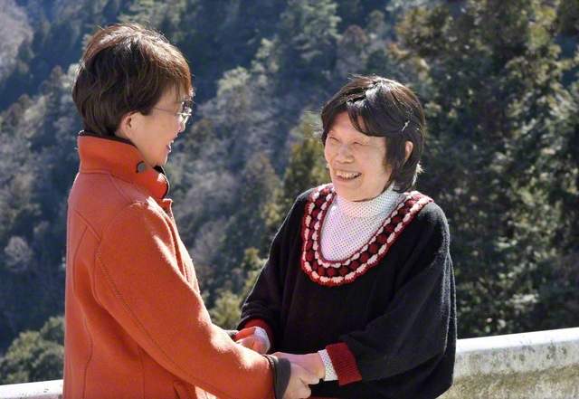 友と手を取り合い、どんな苦難にも負けない信心を貫く小笠原さん㊨