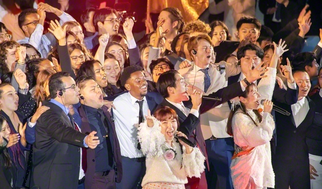 【22日　日米青年平和総会】友情を結び、世界広布を誓い合った日米の青年たちが、ステージに駆け上がり大合唱。会場のボルテージは最高潮に（広島池田平和記念会館で）