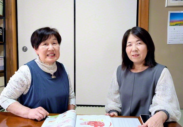 高橋さん㊧は船橋地区女性部長と朗らかに前進する