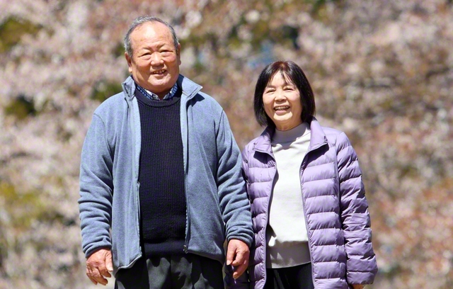 黒滝さん㊨が夫・俊男さんと桜の木の下で