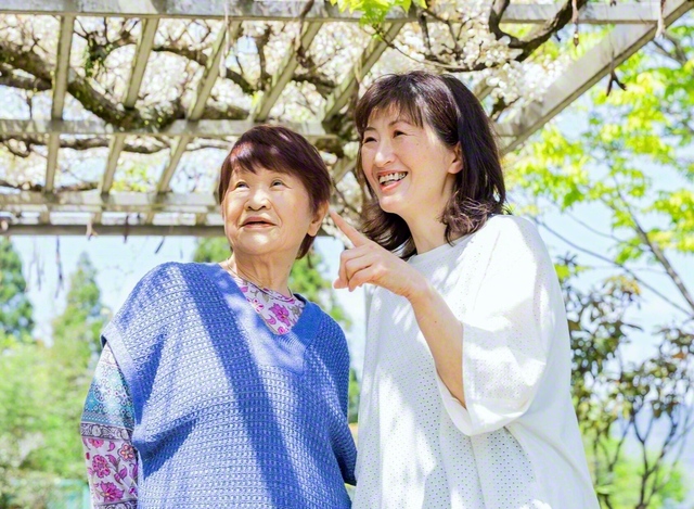 藤棚の下で笑みがこぼれる横平里子さん㊨と母・中山恵子さん
