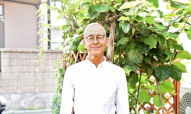 自宅の庭先で穏やかな笑顔を見せる阿部さん。「縁する一人を励ます」との誓いに燃える