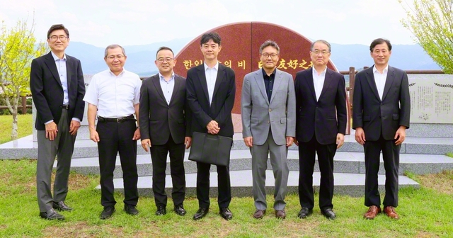 姜錫熙総領事（右から3人目）一行らが、「韓日友好の碑」の前で記念のカメラに（18日、福岡研修道場で）