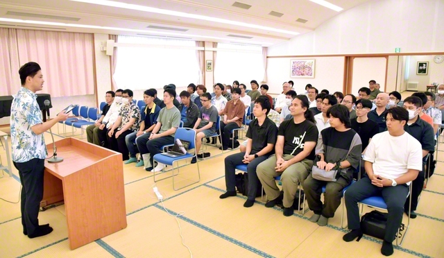 沖縄市の中頭文化会館に集った男子部の友。「沖縄健児の歌」を意気高く歌い、師弟勝利を誓った（8月30日）