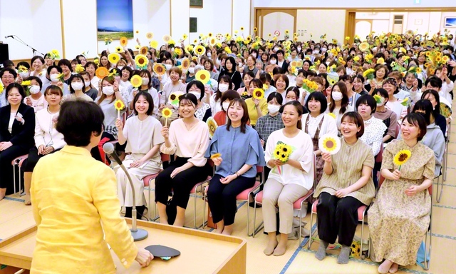 参加者がヒマワリのモチーフを手に、笑顔の花を咲かせた（11日、米子文化会館で）