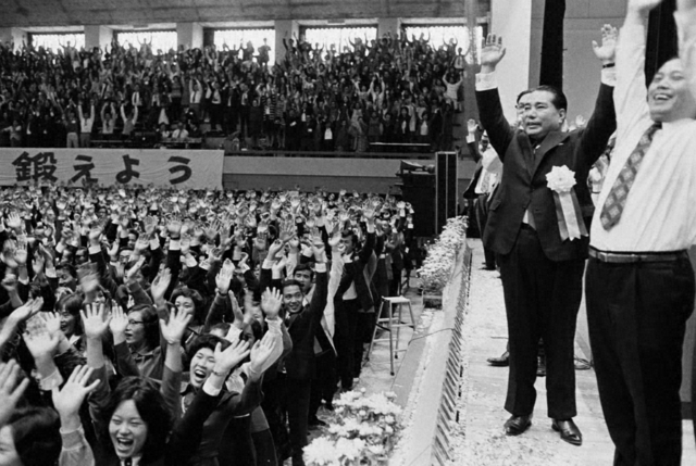 10・13「山梨の日」の淵源となった「山梨広布20年記念総会」で、参加者と万歳をする池田大作先生（1974年10月13日、甲府市内で）