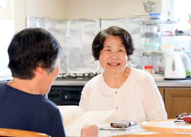 自宅に同志を招き語らう石倉さん㊨