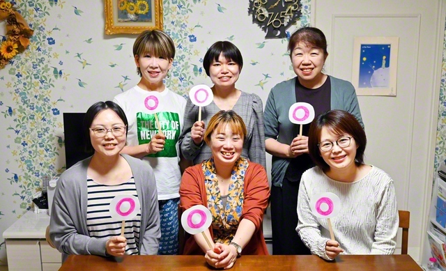 集いでは、渡辺グループ長（後列中央）が司会進行を担当。「大白蓮華」10月号を研さんした後、庄司地区女性部長による○×で答える心理クイズが行われた。互いの解答や結果に笑顔が広がり、和やかな雰囲気に包まれた（2日、仙台市内で）