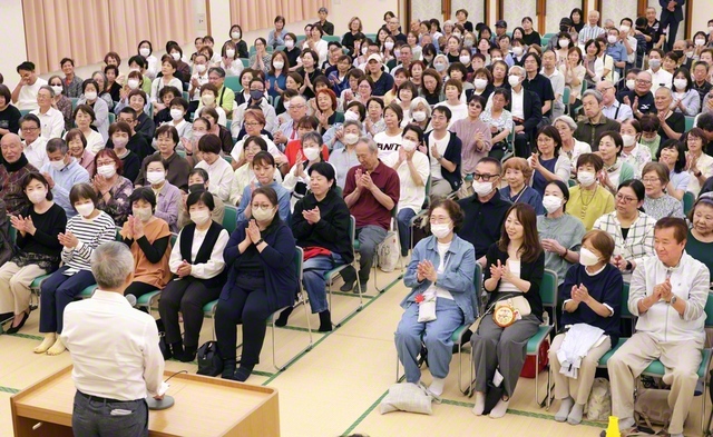 西大阪総県の社会部体験談大会。庄野ひとみさん、川崎正道さん、永栄由記子さん、松本大さんが職場で奮闘する模様を発表し、久保総大阪社会部長があいさつした（11日、西成文化会館で）