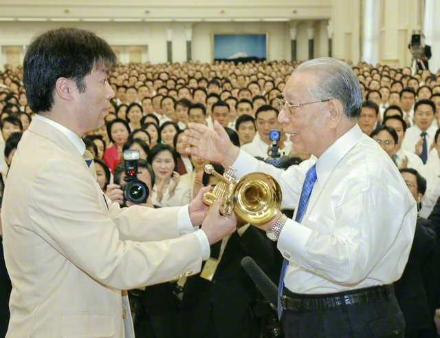 「音楽隊の皆さん、いつも素晴らしい演奏をありがとう！」。本部幹部会の席上、広布の楽雄を讃えて池田先生からトランペットが（2005年12月、東京牧口記念会館で）