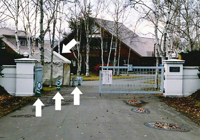 公道から丸見えの「銀月門」内部の様子。裁判所に1991年当時の状況を理解してもらうため、役員がついていたテントを再現し、門扉からの距離を数字（メートル）で示している