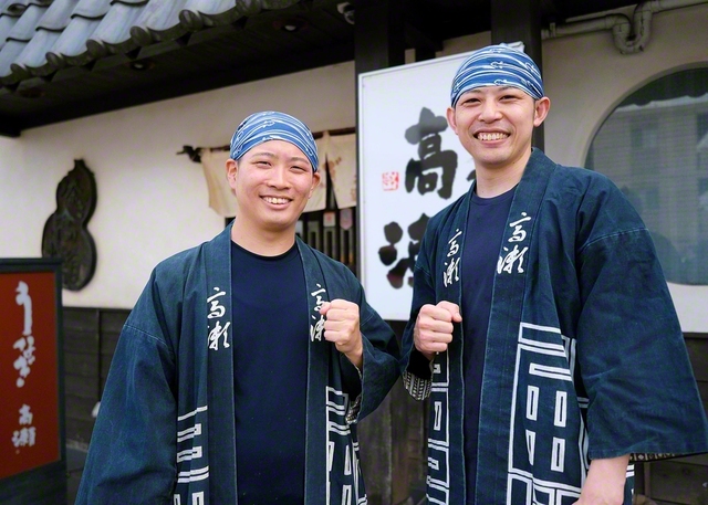 夏のスタミナ源・ウナギを求めて連日、行列ができる繁盛店で働く大山裕さん（34）㊨＝男子地区リーダー＝と上野幸一さん（29）㊧＝同。“お客さまに元気をお届けしたい”との一心で、創業店や新店舗を盛り立ててきた。誠実第一で、きょうもおいしいウナギを提供する