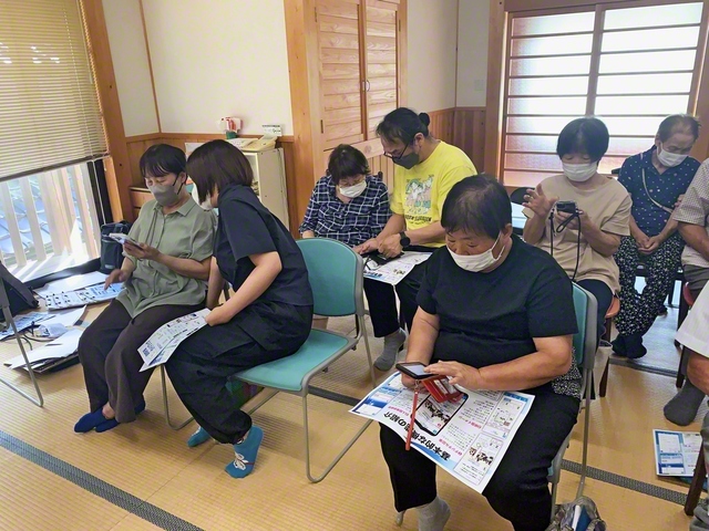 聖教電子版のアプリをダウンロードし、操作する梼原支部の同志（8月31日、梼原町内で）